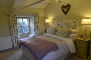 a bedroom with a large bed and a window at Birkend Farmhouse in Feetham