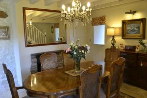 a dining room with a wooden table and a mirror at Birkend Farmhouse in Feetham