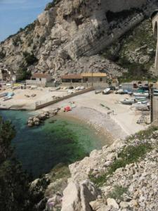una playa con un cuerpo de agua junto a una montaña en Cabanon Calanque Marseille en Le Rove