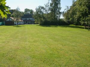 a large grass field with a large house in the background at Silverland in Hordle