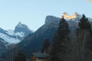 una catena montuosa con una casa in primo piano di appartement dans le centre thermal les Sources Ovronnaz a Ovronnaz