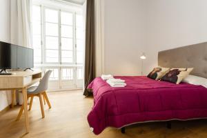 ein Schlafzimmer mit einem großen Bett mit einer lila Decke in der Unterkunft Flamenco by RentCadiz in Cádiz