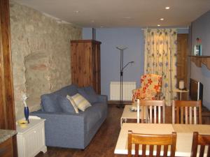 a living room with a blue couch and a table at Apartamentos la Demanda in Ezcaray