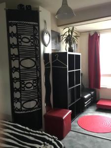 a living room with a bed and a red stool at Anne et Billy in Le Relecq-Kerhuon