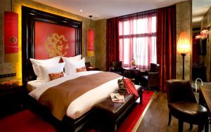 a bedroom with a large bed and a large window at Buddha-Bar Hotel Prague in Prague