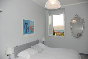 a bedroom with two beds and a mirror and a window at La Nipitella in Montemarcello