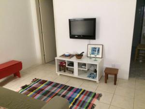 sala de estar con TV de pantalla plana en la pared en Quarto e sala em Copanema, en Río de Janeiro