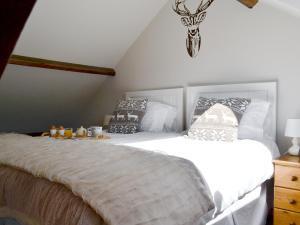 A bed or beds in a room at Kingfisher Cottage 
