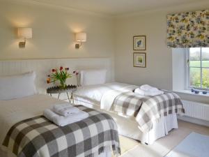 A bed or beds in a room at Greystones Cottage 