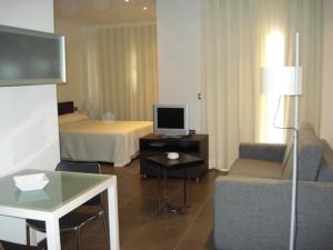 a hotel room with a bed and a tv at Archybal Apartamentos Turísticos y Suites in Archena
