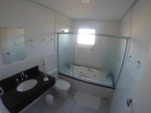 a bathroom with a sink and a shower and a toilet at Plaza Dutra Hotel in Caçapava