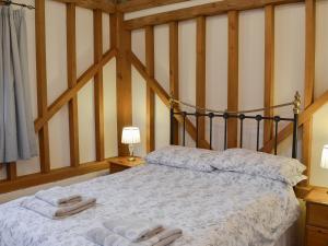 A bed or beds in a room at Rushfields Barn 