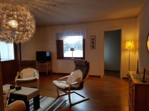 sala de estar con 2 sillas y lámpara de araña en Villa Mia, en Vidsel