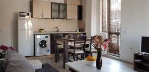 a kitchen and living room with a table and a dining room at Family Aparthotel Vintegra in Burgas