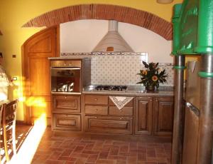 een keuken met houten kasten en een fornuis met oven bij Il Frantoio - a in Lucca