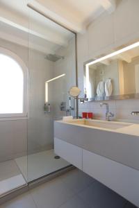 a bathroom with a sink and a mirror at Hotel Spa Genovese in Bonifacio