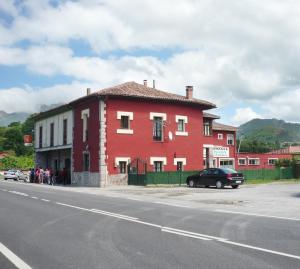 um edifício vermelho no lado de uma rua em La Posada de Granda em Cuenco