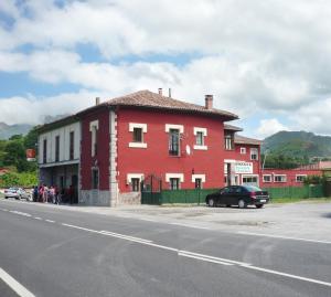 a red building on the side of a street at La Posada de Granda in Cuenco