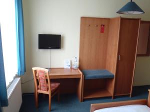 a room with a desk and a chair and a cabinet at Hotel Wutzler in Miesitz