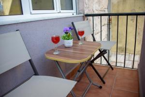 twee glazen wijn op een tafel op een balkon bij Apartman Dijana in Kotor