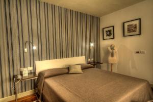 una camera con letto e tavolo con lampada di Hotel Datini a Prato