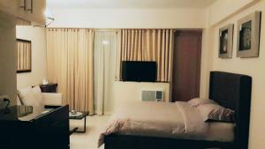 sypialnia z łóżkiem i telewizorem w obiekcie Palm Tree Villas 1 w mieście Manila