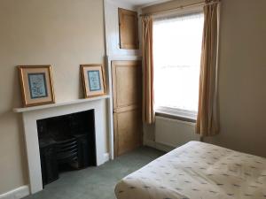 um quarto com uma lareira, uma janela e uma cama em Seventeen Latham em Preston