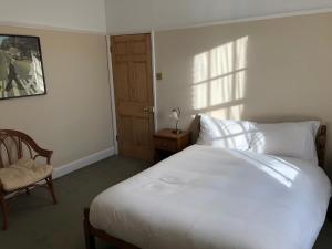 a bedroom with a large white bed and a chair at Seventeen Latham in Preston