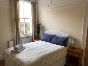 um quarto com uma cama com almofadas azuis e uma janela em Seventeen Latham em Preston