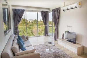 a living room with a couch and a tv at The Bleu condo unit in Chaweng