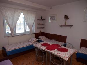 ラシンにあるPokoje Gościnne "Amelia"のベッド2台とテーブルが備わる客室です。