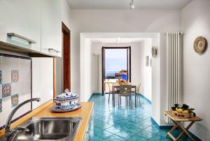 een keuken met een wastafel en een tafel met uitzicht bij Elena Apartment in Piano di Sorrento