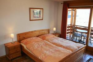 a bedroom with a bed and a balcony with a table at Résidence Castel Club Leysin Parc in Leysin