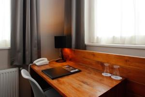 a wooden desk with a phone and a book on it at Hotel Aan De Singel in Delfzijl