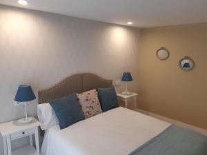 1 dormitorio con 1 cama con 2 mesas y 2 lámparas en Apartamentos Nájera, en Nájera