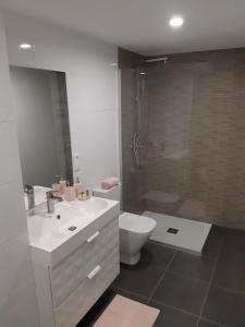een badkamer met een toilet, een wastafel en een douche bij Apartamentos Nájera in Nájera
