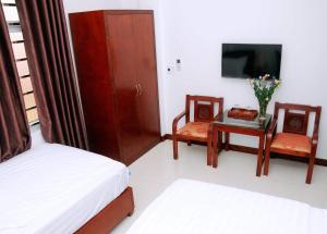a room with two beds and a tv and a table at Sunflower Hotel in Ninh Binh
