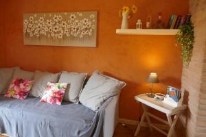 una camera con divano e tavolino con lampada di Appartamento di Charme Suite Sole a Lazise Altre 13 foto