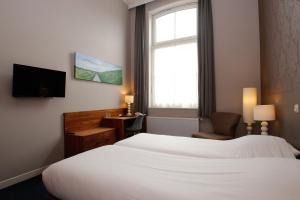 Hotel Aan De Singel tesisinde bir odada yatak veya yataklar