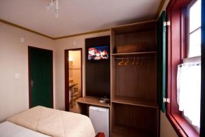 a bedroom with a bed and a tv in a room at Pousada Do Ouvidor in Ouro Preto