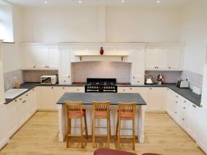 a kitchen with a table with four chairs around it at The Barn in Landkey