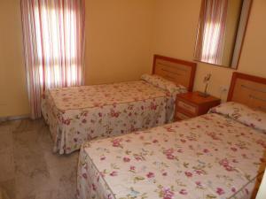 a bedroom with two beds and a mirror at Casinomar in Benalmádena