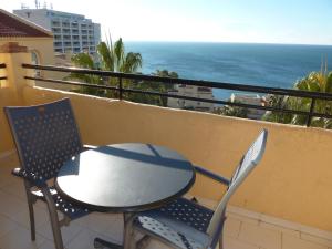 stół i krzesła na balkonie z widokiem na ocean w obiekcie Casinomar w mieście Benalmádena
