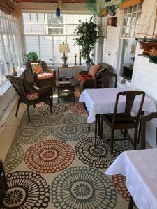 Bayside Inn في ديغبي: غرفة معيشة بها طاولات وكراسي وغرفة بها