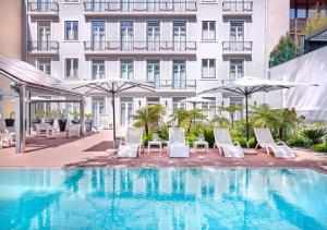 a hotel with a pool and chairs and umbrellas at Hapimag Apartments Lisbon in Lisbon