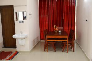 a bathroom with a table and a sink and a toilet at Indeevaram Residency in Trivandrum