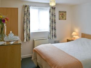 A bed or beds in a room at Honeysuckle Cottage 
