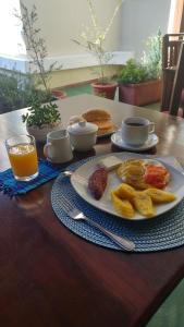 a table with a plate of breakfast foods and orange juice at Hostal Donde Regina in Guatemala