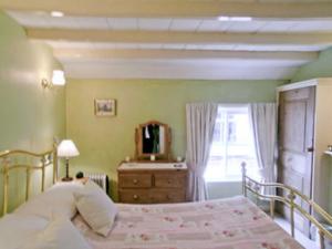 A bed or beds in a room at Pilgrim Cottage 