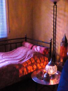 een slaapkamer met een bed en een tafel met een lamp bij ROSE'S Ferienwohnung in Bernbach